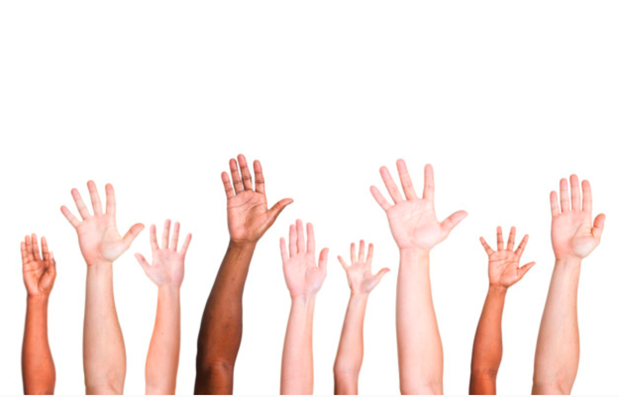 diverse group of hands reaching up